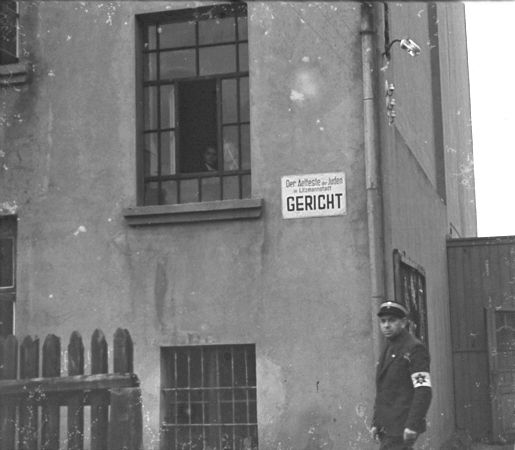 A Jewish policeman stands guard outside the ghetto courthouse